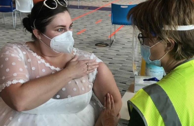 تتلقى اللقاح بفستان الزفاف