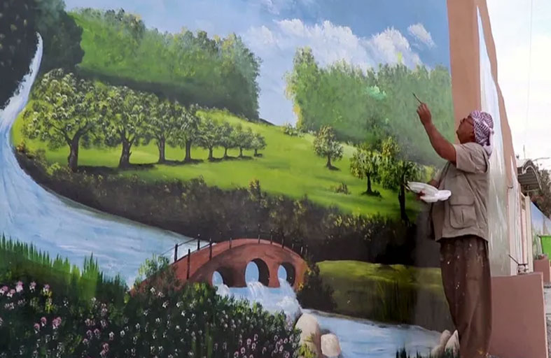 يزيّن ساحة قريته باللوحات الجدارية