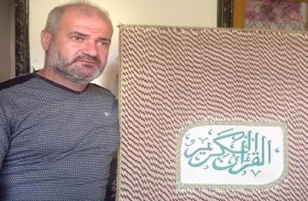 سوري يكتب القرآن الكريم بخط يده