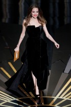 الممثلة أنجلينا جولي مرتدية فستانا من تصميم فيرساتشي، أثناء تقديمها جائزة الأوسكار لأفضل سيناريو مقتبس في حفل توزيع جوائز الأوسكار بهوليوود. (رويترز)