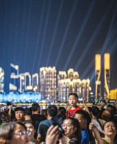 زوار يتجمعون في منتزه نهر تشيانتانغ لمشاهدة العرض الضوئي لملعب مركز هانغتشو الرياضي الأولمبي. ا ف ب