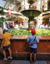 طفل وطفلة ينظران إلى نافورة مليئة بالبطيخ في متجر GUM وسط موسكو. (ا ف ب)