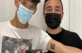 يضع تصريحه الصحي وشماً على ذراعه