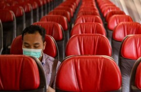 متسلحا بالكمامة.. وحيدا في الطائرة إلى بؤرة الوباء