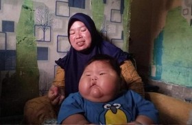 طفل ضخم بعمر 16 شهراً يرتدي ملابس والده