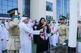 حصة بو حميد وعبد الرحمن العور يرفعان علم الإمارات على مبنى وزارتي تنمية المجتمع والموارد البشرية والتوطين